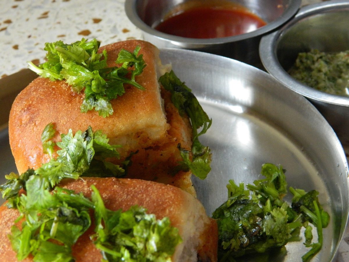 Dabeli, a spiced potato filling in a toasted bun topped with peanuts and pomegranate